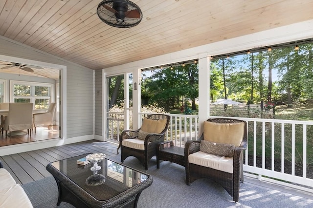 sunroom / solarium with wood ceiling, vaulted ceiling, and ceiling fan