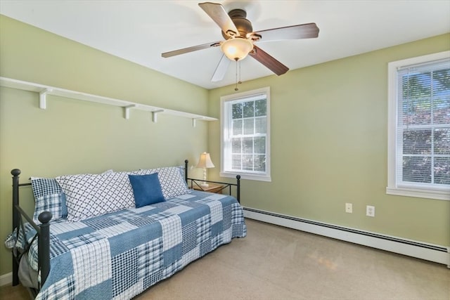 carpeted bedroom with ceiling fan and a baseboard radiator