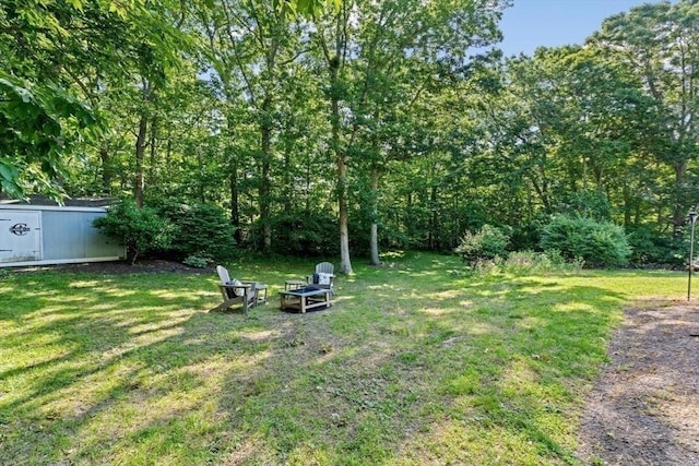 15 Surrey Ln, Sandwich, MA 02563 - view of grassy yard featuring an outdoor fire pit