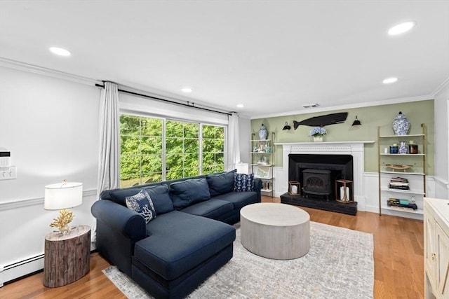 15 Surrey Ln, Sandwich, MA 02563 - living area with baseboard heating, crown molding, a wood stove, wood finished floors, and recessed lighting