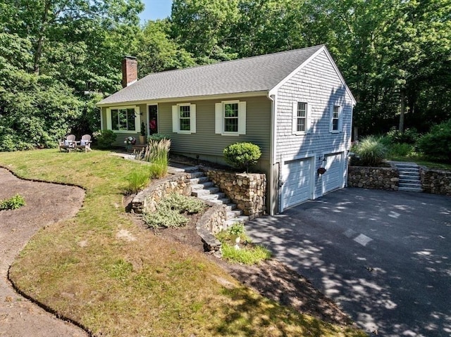 15 Surrey Ln, Sandwich, MA 02563 - ranch-style house with stairs, driveway, an attached garage, a chimney, and a front lawn