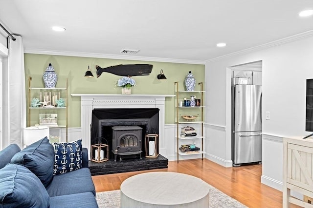 15 Surrey Ln, Sandwich, MA 02563 - living area with a wood stove, wood finished floors, ornamental molding, and recessed lighting
