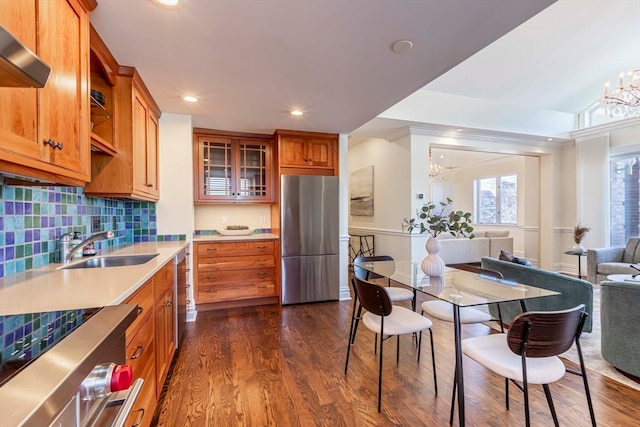 kitchen featuring dark hardwood / wood-style floors, sink, a notable chandelier, stainless steel appliances, and backsplash