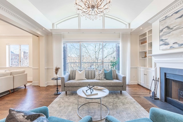 living room with built in shelves, a notable chandelier, vaulted ceiling, and dark hardwood / wood-style flooring