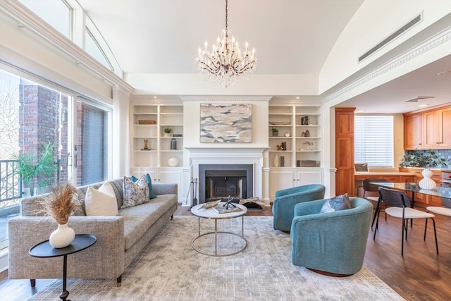 living room featuring wood-type flooring, vaulted ceiling, and an inviting chandelier