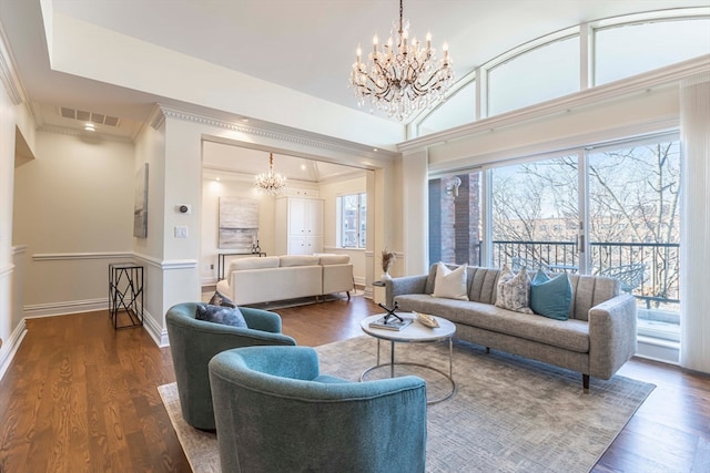 living room featuring ornamental molding, dark hardwood / wood-style flooring, and a chandelier