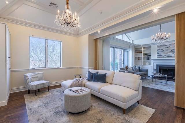 living room featuring a notable chandelier, crown molding, dark wood-type flooring, and a healthy amount of sunlight