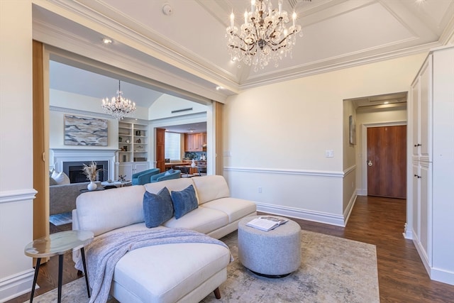 living room featuring crown molding, dark hardwood / wood-style flooring, built in features, and a notable chandelier