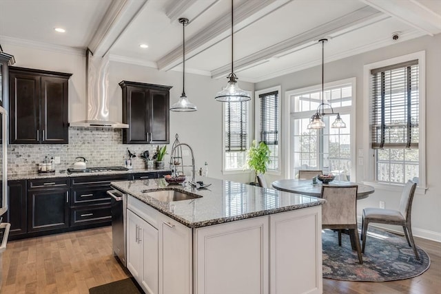 kitchen with light wood-style floors, stainless steel gas stovetop, beam ceiling, and a sink