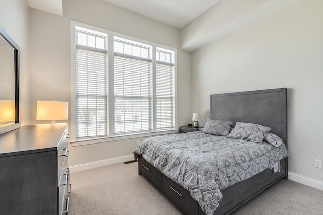 bedroom with light carpet and baseboards