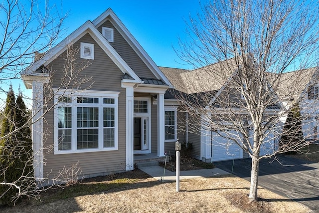 view of front of home featuring a garage, a standing seam roof, metal roof, and concrete driveway