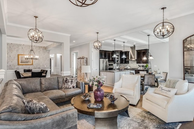 living area featuring light wood finished floors, ornamental molding, and a notable chandelier