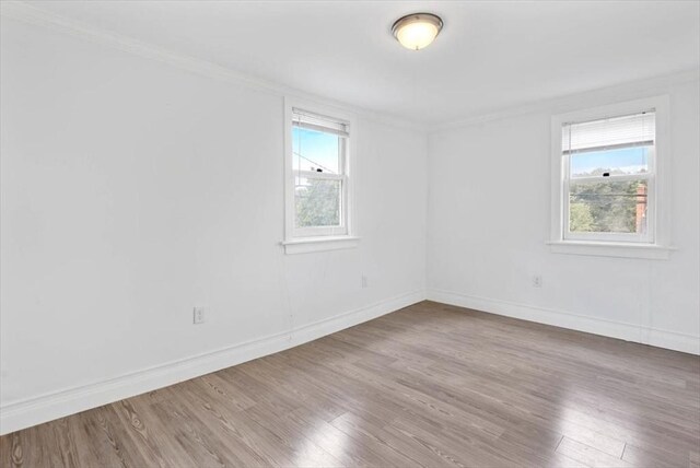 7 New Bridge St, Hingham, MA 02043 - empty room featuring wood finished floors, ornamental molding, plenty of natural light, and baseboards