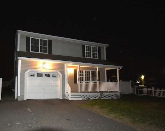 traditional-style house featuring a porch, fence, and driveway