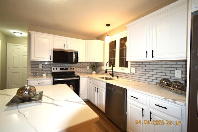 kitchen with white cabinets, stainless steel appliances, a sink, and tasteful backsplash