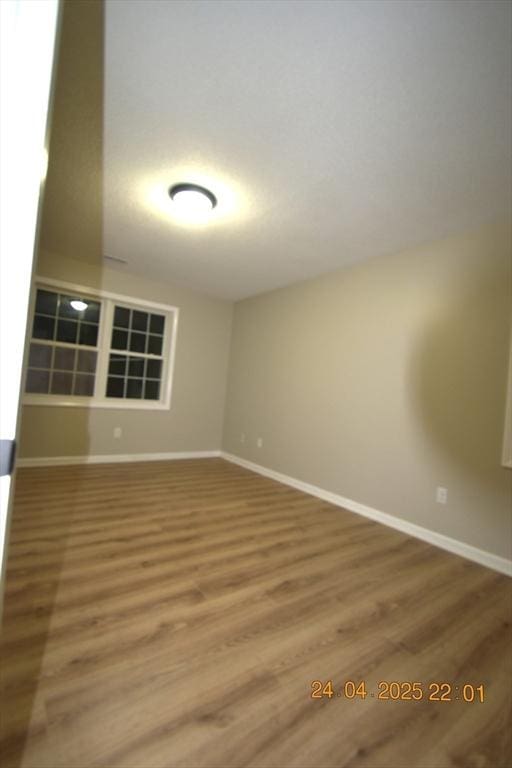 empty room featuring baseboards and wood finished floors