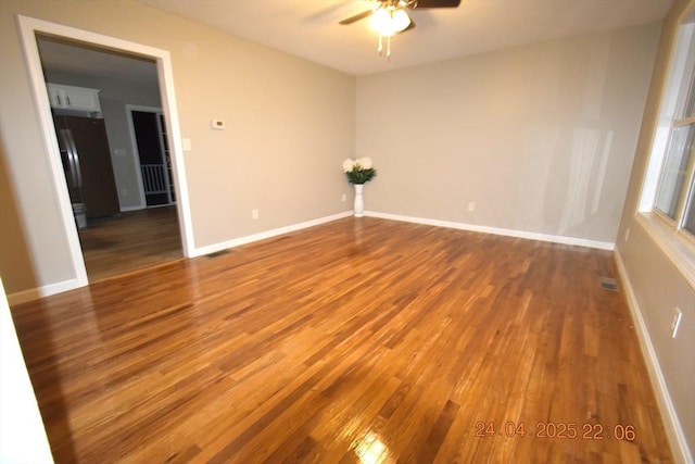 unfurnished room featuring baseboards, a ceiling fan, and wood finished floors
