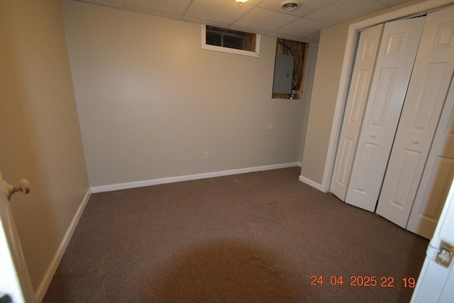 unfurnished bedroom with a closet, baseboards, electric panel, and dark colored carpet