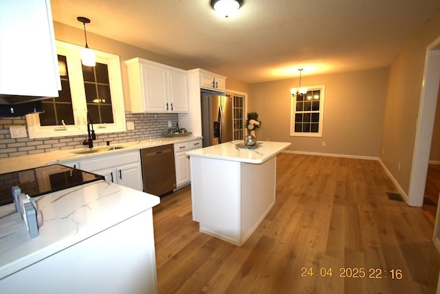 kitchen with baseboards, white cabinetry, a sink, appliances with stainless steel finishes, and backsplash