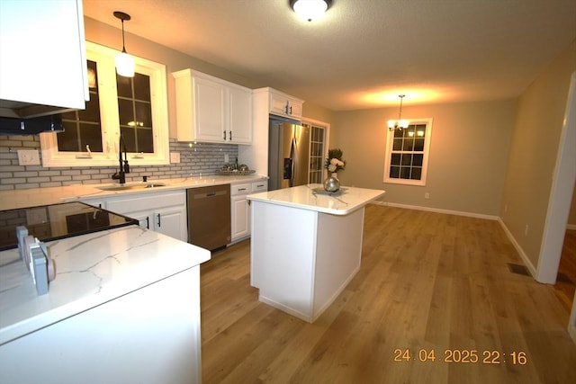 kitchen with decorative backsplash, baseboards, white cabinetry, a sink, and appliances with stainless steel finishes