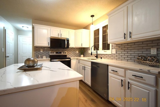 kitchen with a sink, appliances with stainless steel finishes, white cabinets, and tasteful backsplash