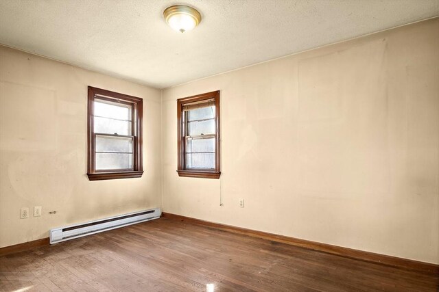 unfurnished room with a textured ceiling, wood finished floors, baseboards, and a baseboard radiator