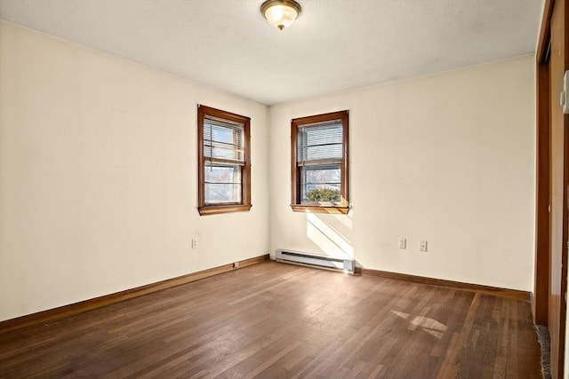 unfurnished room featuring a baseboard radiator, baseboards, and wood finished floors