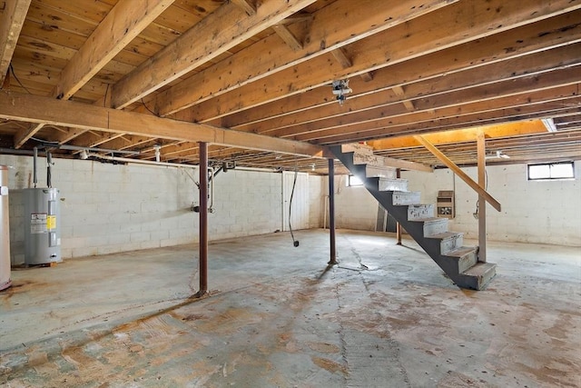 basement with electric water heater, stairs, and water heater