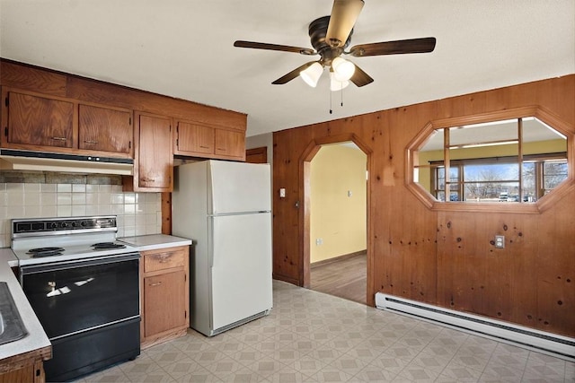 kitchen featuring under cabinet range hood, light floors, baseboard heating, range with electric stovetop, and freestanding refrigerator