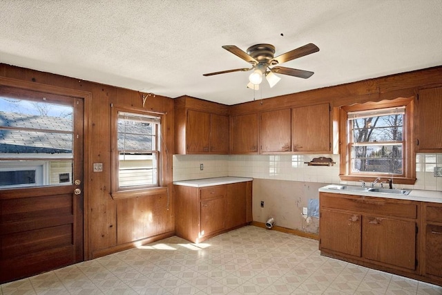 kitchen with a textured ceiling, brown cabinets, light floors, and light countertops