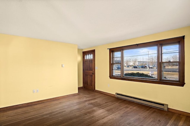 empty room featuring baseboards, baseboard heating, and wood finished floors