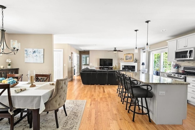 53 Gilbert Rd, Southampton, MA 01073 - dining room featuring a chandelier, light wood-style floors, a ceiling fan, a fireplace, and recessed lighting