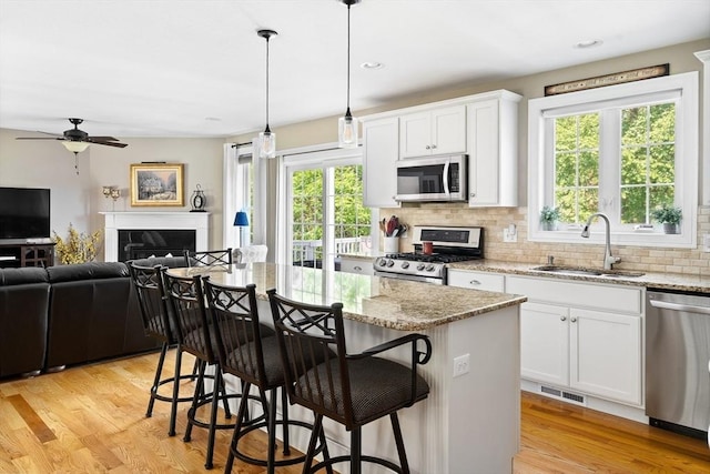 53 Gilbert Rd, Southampton, MA 01073 - kitchen featuring stainless steel appliances, a sink, decorative backsplash, open floor plan, and white cabinets