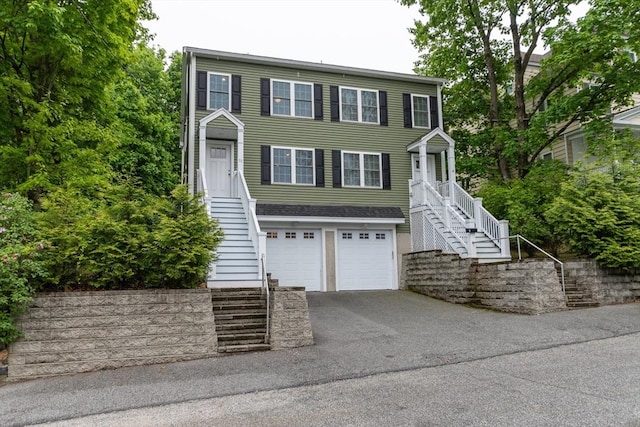 view of front facade with stairway, driveway, and a garage