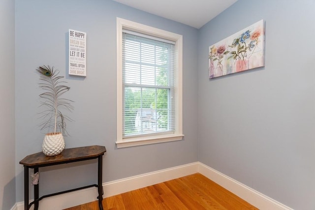 doorway with wood finished floors and baseboards