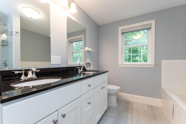 full bath with toilet, a garden tub, an enclosed shower, double vanity, and baseboards