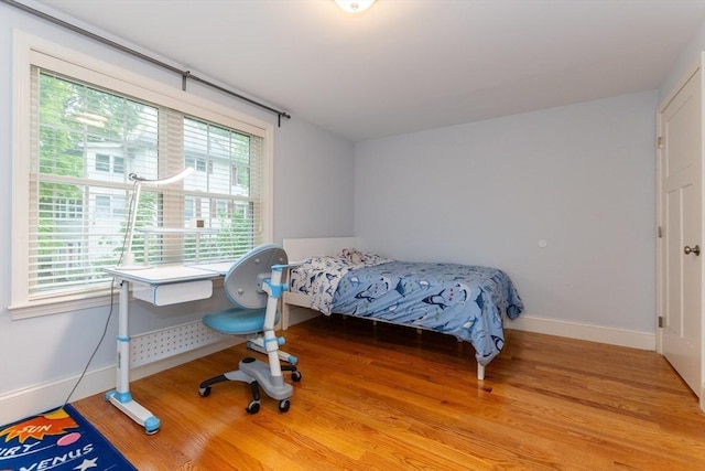 bedroom with baseboards and wood finished floors
