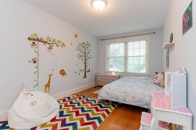 bedroom featuring wood finished floors and baseboards