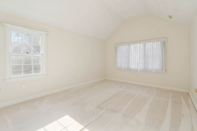 unfurnished room with lofted ceiling and light carpet