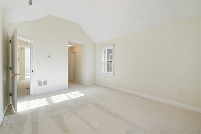 unfurnished room with light carpet and vaulted ceiling