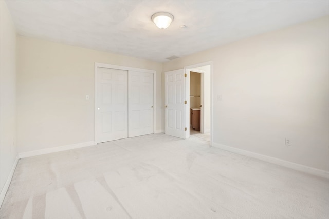 unfurnished bedroom with a closet and light colored carpet