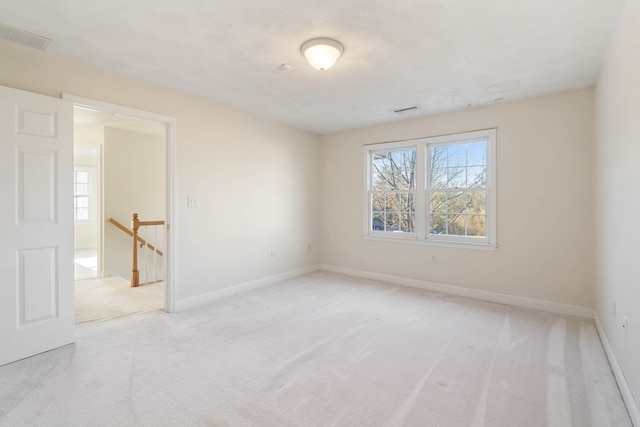 spare room featuring light carpet