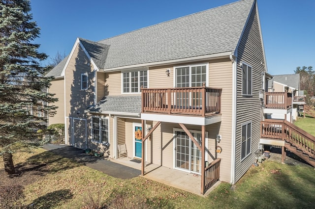 rear view of property with a yard, a balcony, and a patio