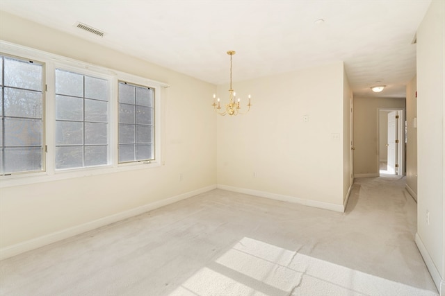 carpeted spare room with a notable chandelier