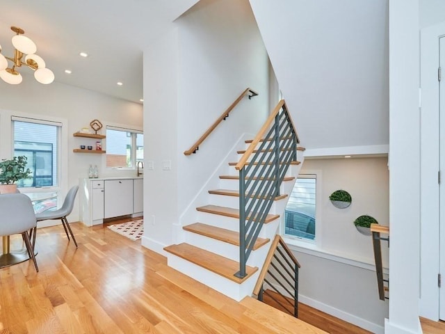 stairs with baseboards, a chandelier, wood finished floors, and recessed lighting