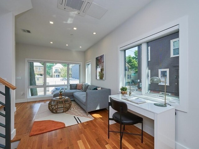 living area featuring visible vents, stairway, wood finished floors, and recessed lighting