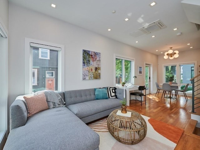 living area featuring a chandelier, recessed lighting, a healthy amount of sunlight, and light wood finished floors