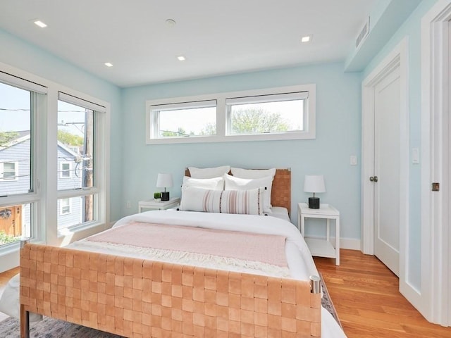 bedroom featuring light wood-style floors, recessed lighting, visible vents, and baseboards