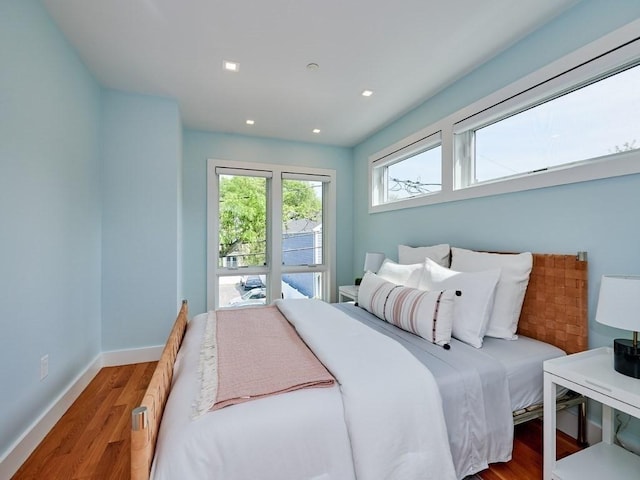 bedroom featuring baseboards, wood finished floors, and recessed lighting