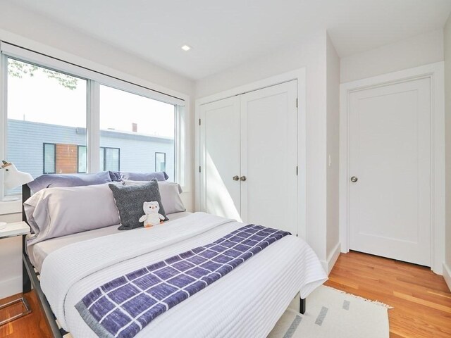 bedroom with light wood-style floors, baseboards, a closet, and recessed lighting